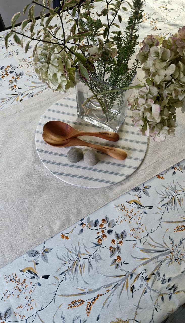 Mantel Sofía en ambiente, con centro de mesa de hortensias en florero de vidrio y cucharas de madera Tischdecke
