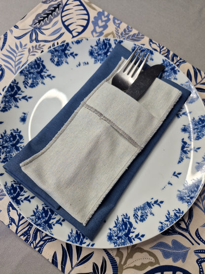 Puesto de mesa con servilleta azul piedra, funda de cubiertos en lino y plato azul y blanco