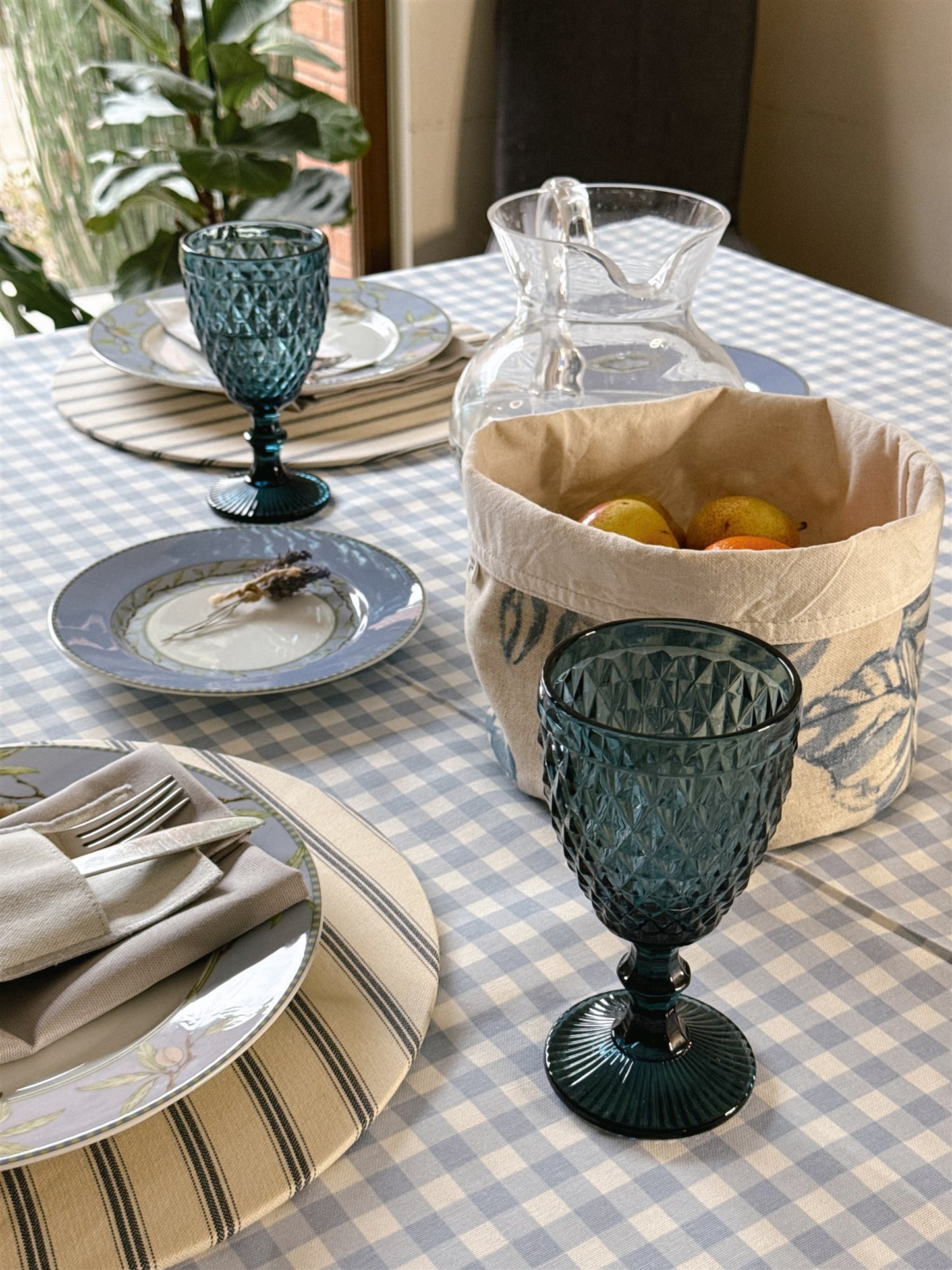 Mesa con mantel vichy celeste y luz natural