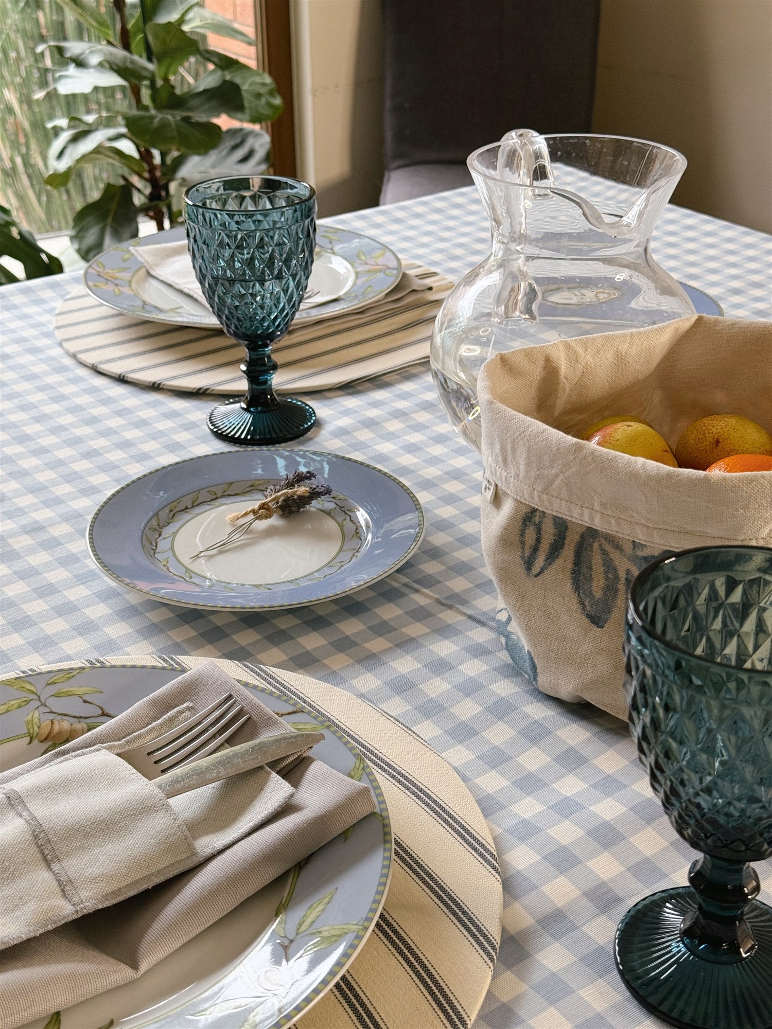 Mantel rectangular repelente vichy celeste sobre mesa puesta