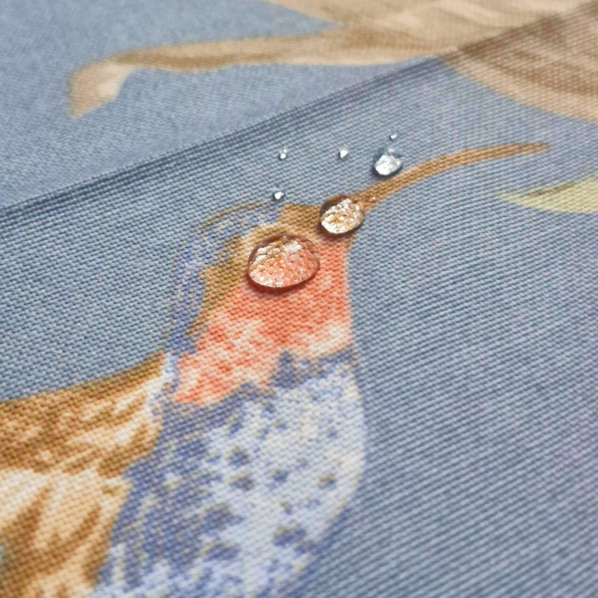 Gotas de agua sobre mantel Picaflor Azul mostrando el efecto repelente