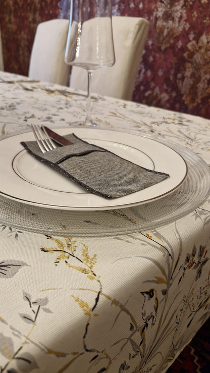 Porta cubiertos de lino marengo sobre plato en mesa puesta
