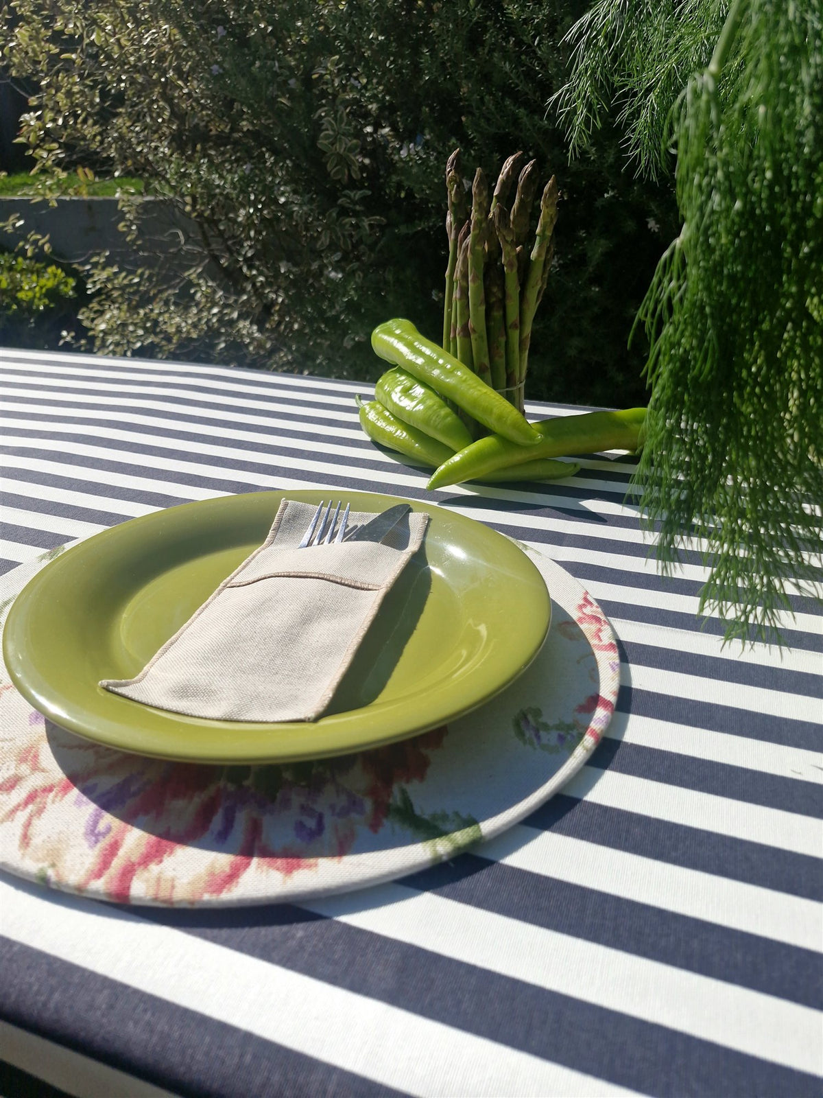 Detalle mantel repelente Rayas Marengo con individual floral y plato verde