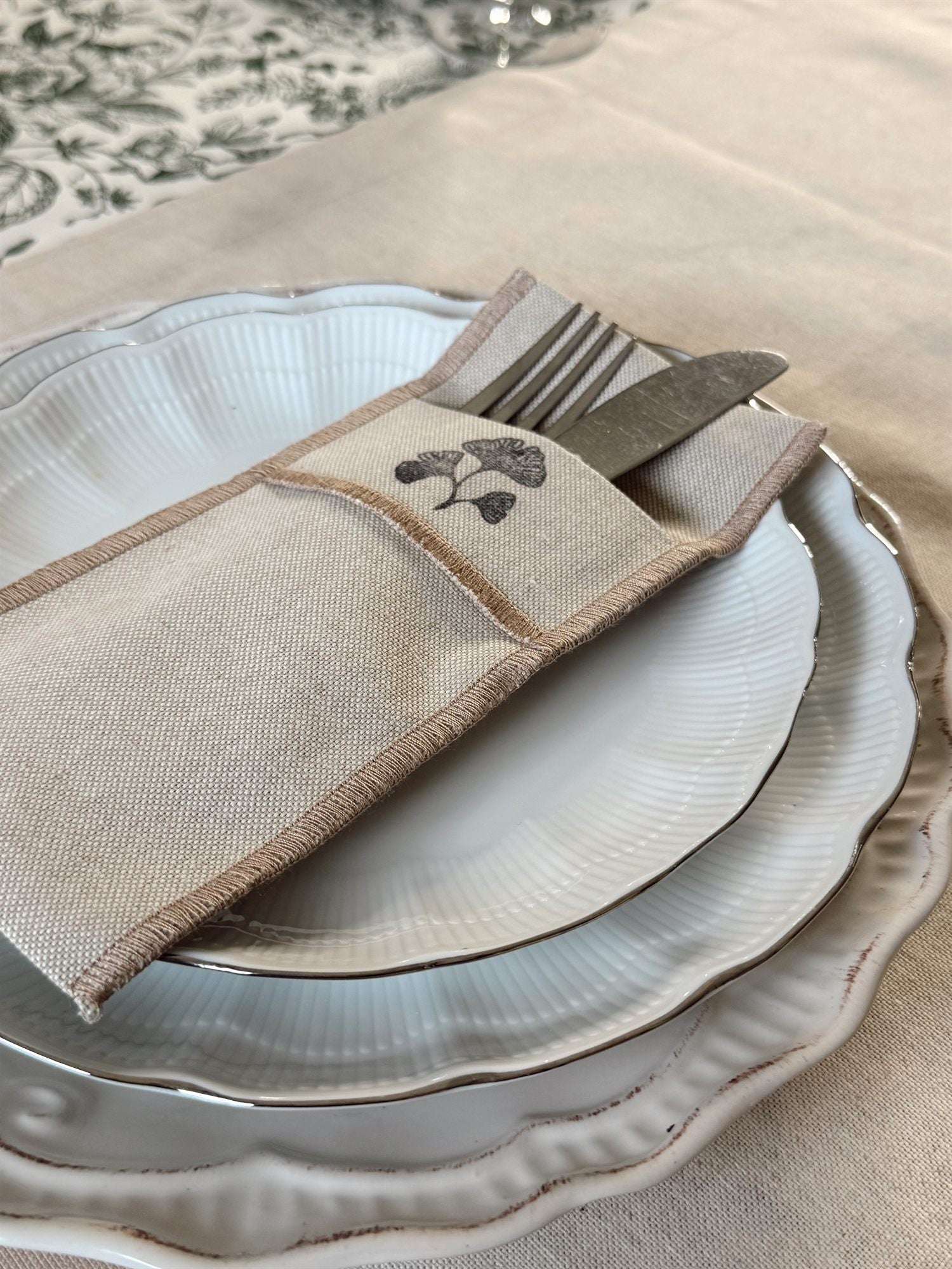 Servilleta de lino Tischdecke con estampado ginkgo sobre vajilla blanca